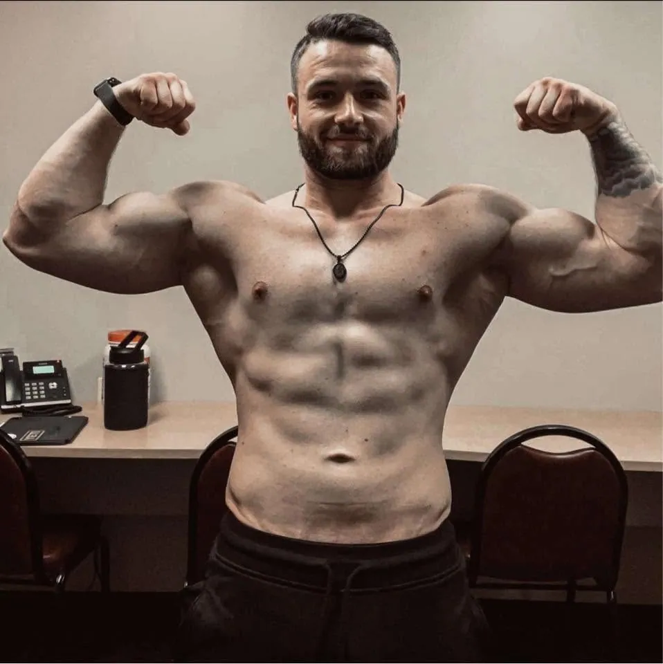 Brandon Manning flexing both arms and smiling at the camera